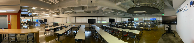 A panoramic view of the Reactor showing desks and Surface Hubs